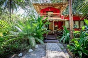 a red house with a staircase leading to it at Mata N'ativa Pousada in Trancoso