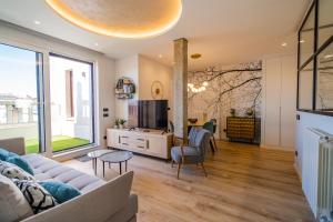 a living room with a couch and a tv at Catedral - Apartamentos Burgos Deluxe in Burgos