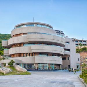 a large building with a parking lot in front of it at Ohana Village in Phương Phi