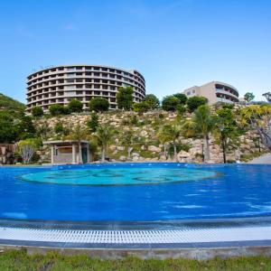 a large blue swimming pool in front of a building at Ohana Village in Phương Phi