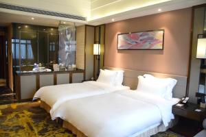two beds in a hotel room with a window at Ramada Foshan Hotel in Foshan