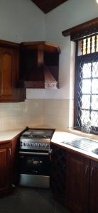 a kitchen with a stove and a window in it at Wilson Bungalow Kandy in Kandy