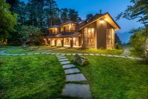 uma casa com um caminho de pedra em frente em Hotel Eagles Nest em Dharamshala