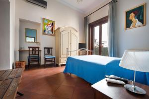 Habitación de hotel con cama, mesa y sillas en B&B Casa Degli Artisti, en Palermo