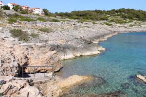 a rocky shoreline with a body of water at Apartments with a parking space Mali Losinj (Losinj) - 8090 in Mali Lošinj