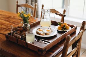 uma mesa de madeira com pratos de comida, ovos e leite em Brackenridge Country Retreat & Spa em Martinborough