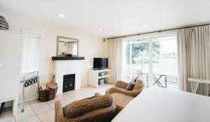 a living room with a fireplace and a tv at Brackenridge Country Retreat & Spa in Martinborough 