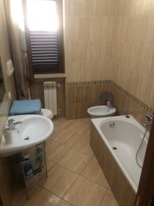 bagno con 2 lavandini, vasca e servizi igienici di holiday home a Vasto