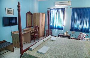 a bedroom with a bed and a desk and a television at Anuraag Villa in Jaipur