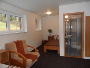 a living room with a chair and a bathroom at Vila Kamila in Janske Lazne