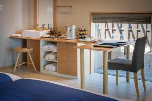 a kitchen with a table and a chair in a room at Auberge Fontaine Bleau Atami in Atami