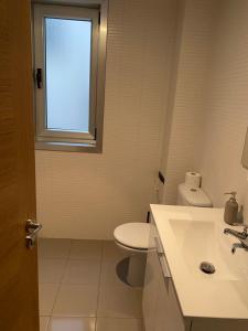 łazienka z toaletą, umywalką i oknem w obiekcie Costa da morte w mieście Malpica