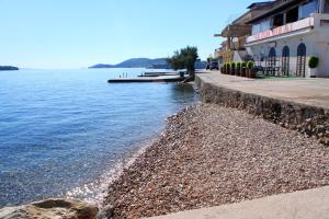 plaża obok zbiornika wodnego z budynkami w obiekcie Apartment Preko 8384c w mieście Preko