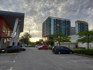 a parking lot with cars parked in front of tall buildings at Sunset View 969 PD Waterfront in Port Dickson