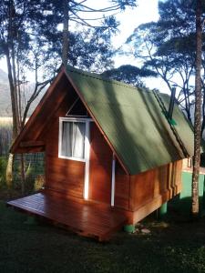 a small wooden cabin with a green roof at Chalés Snow in Urubici