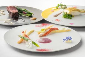 três pratos com diferentes tipos de alimentos sobre eles em Auberge Fontaine Bleau Atami em Atami
