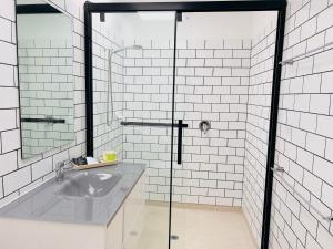 a bathroom with a sink and a glass shower at Sandpiper Motel Apollo Bay in Apollo Bay