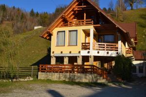 a house with a wooden roof on a hill at Pensiunea Dor de munte in Bran
