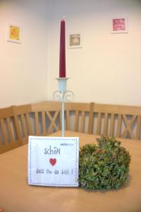 eine Kerze auf einem Tisch mit einem Schild in der Unterkunft Ferienwohnungen Vierthaler in Filzmoos