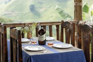 a table with a bottle of wine and glasses on it at Chapa Farmstay - Mountain Retreat in Sa Pa