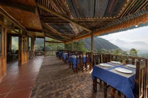 a restaurant with tables and chairs on a balcony at Chapa Farmstay - Mountain Retreat in Sa Pa