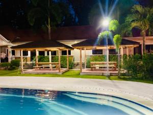 a house with a swimming pool at night at 3 Peaks Resort & Boutique Hotel in Lipa