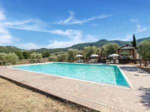 - une piscine dans un complexe avec des montagnes en arrière-plan dans l'établissement Belvilla by OYO La Casa dei Due Olivi, à Quarrata