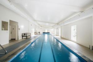 an indoor swimming pool with blue water in a building at Brackenridge Country Retreat & Spa in Martinborough 