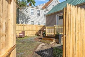 una valla de madera frente a una casa en NEW!! Lovely unit w/ PRIVATE Hot Tub and patio!, en Laconia