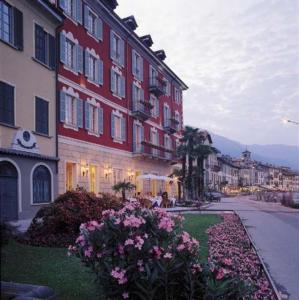een groep gebouwen op een straat met bloemen bij Hotel Cannobio in Cannobio