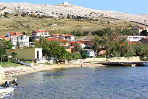 a small town on the shore of a body of water at Apartments by the sea Dinjiska, Pag - 9386 in Povljana