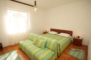 ein Schlafzimmer mit einem Bett und einem Sofa in der Unterkunft Apartments by the sea Ugljan - 8264 in Ugljan