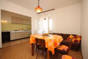 a kitchen and dining room with a table and a couch at Apartments by the sea Ugljan - 8264 in Ugljan