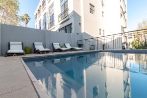 a swimming pool with lounge chairs next to a building at Hippo Boutique Hotel in Cape Town