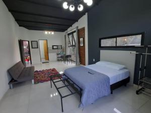 um quarto com uma cama e uma cadeira em Naturalis Flats and Suites em Puerto Iguazú