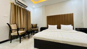 a bedroom with a large bed and chairs in it at Hotel Double1 in Islamabad
