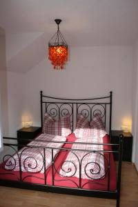 GrinsにあるFerienwohnung Leitnerのベッドルーム1室(赤いベッド1台、シャンデリア付)