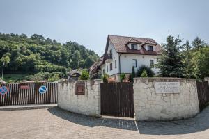 ein Haus hinter einem Zaun mit einem Schild darauf in der Unterkunft Apartament Pod Aniołem - 44 in Kazimierz Dolny
