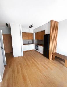 een grote keuken met witte kasten en een houten vloer bij Elegant 1-Bedroom Flat With Balcony Near Wrocław in Wrocław