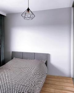 ヴロツワフにあるElegant 1-Bedroom Flat With Balcony Near Wrocławのベッドルーム1室(ベッド1台、白黒の掛け布団付)