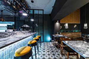 ein Restaurant mit einer Bar mit Hockern und Tischen in der Unterkunft 19 Tile Ceramic Concept - by Unlock Hotels in Caldas da Rainha