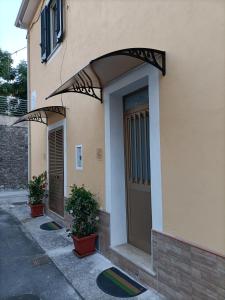 un bâtiment avec une porte et des plantes en pot devant lui dans l'établissement Oltremare Case Vacanza, mini appartamenti, à Diamante