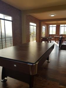 a large ping pong table in a room with windows at CASA DE CAMPO INTI PACHA Coroico 