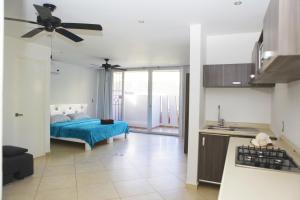 a bedroom with a blue bed and a kitchen at Iris Studios & Apartments in Playa del Carmen