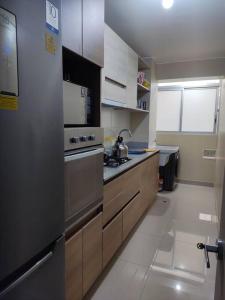 cocina con fogones y armarios de acero inoxidable en Departamento Full en Lince en Lima