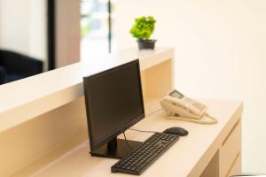 a desk with a computer monitor and a phone at Thip Thip Hotel in Ban Khlong Chi Lat