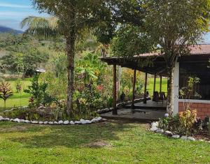 un pabellón en un jardín con árboles y césped en Selva Mayo, en Moyobamba