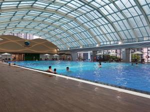 uma grande piscina interior com pessoas em Apartment 1BR-FL09th-R103 Building-Vinhomes Ocean Park 