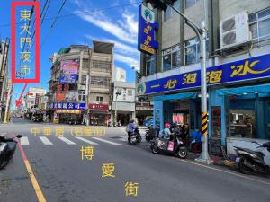 a street in an asian city with people riding scooters at 市中心電梯民宿-全新開幕&近東大門夜市 in Hualien City