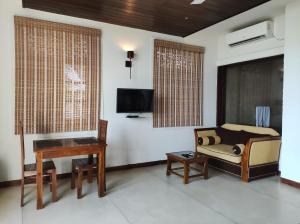 ein Wohnzimmer mit Sofa und Klavier in der Unterkunft Hotel Leaf on Lagoon in Katunayaka
